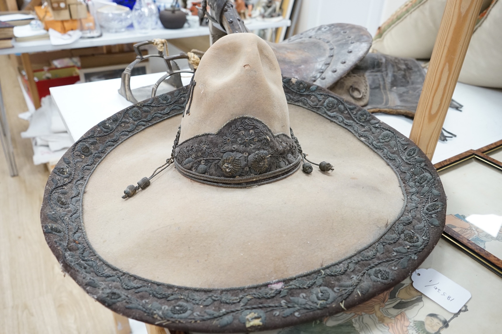 A Spanish Colonial leather saddle and a Spanish Colonial bullion work sombrero, saddle 59cm long